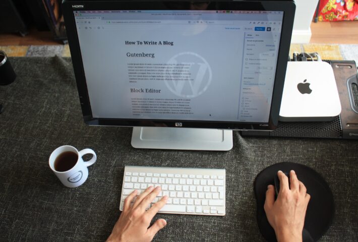 SEO-content optimalisatie. Computer met toetsenbord, muis en kop koffie. Op het beeldscherm staat een blog omgeving in workpress afgebeeld