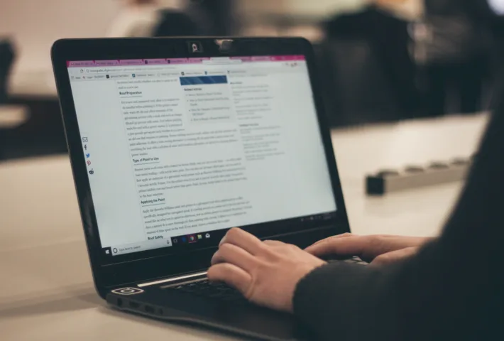 Tekschrijver bezig met het schrijven van een websitetekst op laptop.